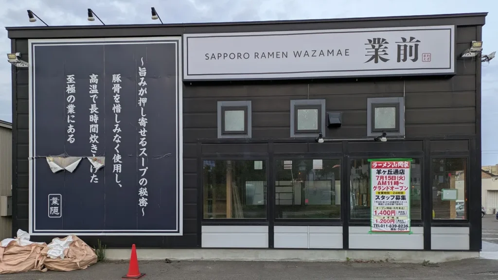 旧店名「業前」の看板が残る建物に山岡家のオープン日の看板が映る改装中の様子（2025年5月21日撮影）